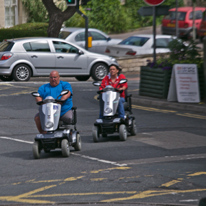 People crossing the road on mobility scooters